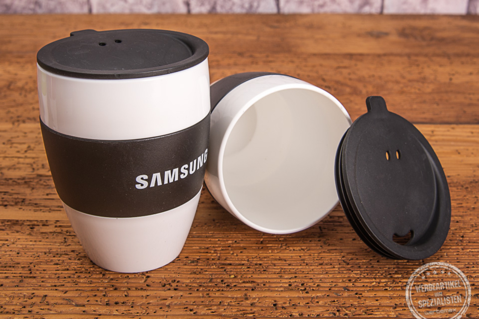 Kaffeebecherr to go mit schwarzem Deckel und schwarzer Manschette als Werbemittel von Koziol