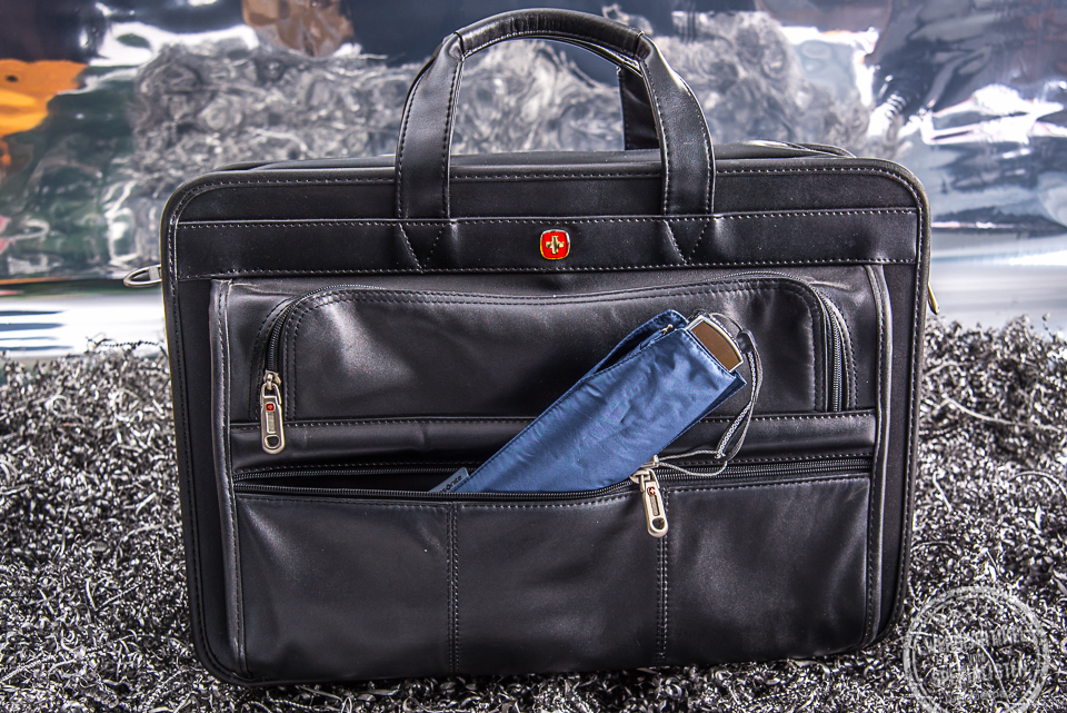 Kompakter Hand&ouml;ffner Regenschirm von Samsonite in Dunkelblau in einer Aktentaschen verstaut. Der kleine Reiseschirm passt in jede Tasche.