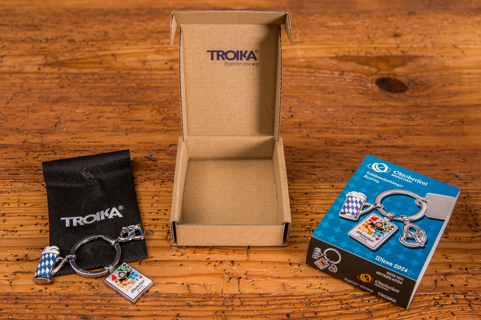 Oktoberfest Schl&uuml;sselanh&auml;nger von der Marke Troika. Der Schl&uuml;sselanh&auml;nger besteht aus 3 Anh&auml;ngern: bayerischer Ma&szlig;krug, Brezel und dem Oktoberfest Logo mit dem M&uuml;nchner Kindl. Der Marken-Schl&uuml;sselanh&auml;nger kommt verpackt in einem kleinen schwarzen S&auml;ckchen, dass in einer ansprechenden Kartonage verpackt ist. 
