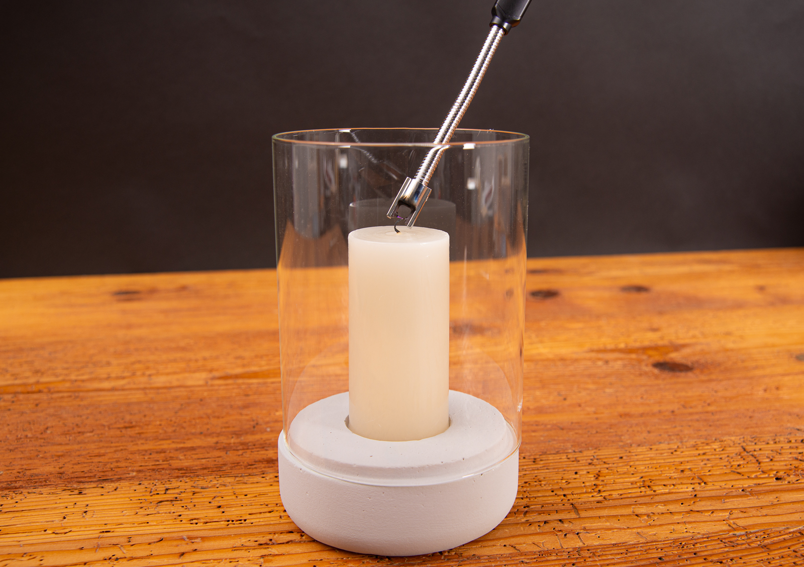 Kerze in Windlicht, die mit einem Messeartikel FutureEcoFlex Lichtbogen Feuerzeug angez&uuml;ndet wird.