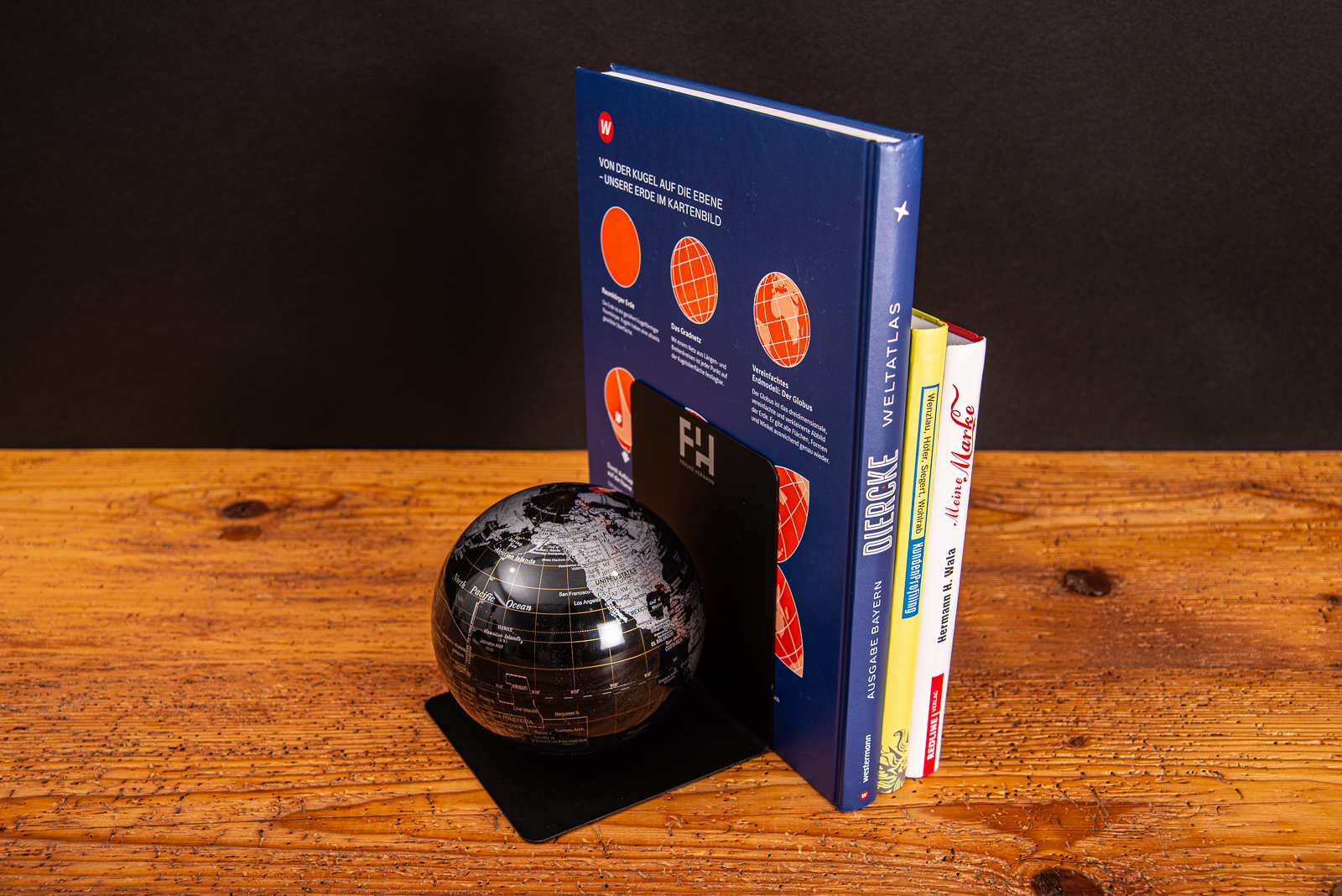 Troika Globus Buchst&uuml;tze mit abgest&uuml;tzen B&uuml;chern auf Holztisch.