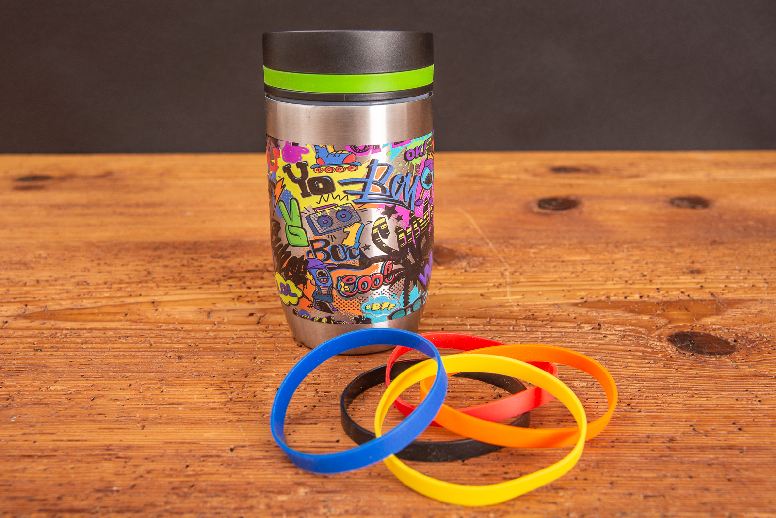 Ein rundum bedruckter Thermobecher mit austauschbaren Gummiringen als Werbeartikel.