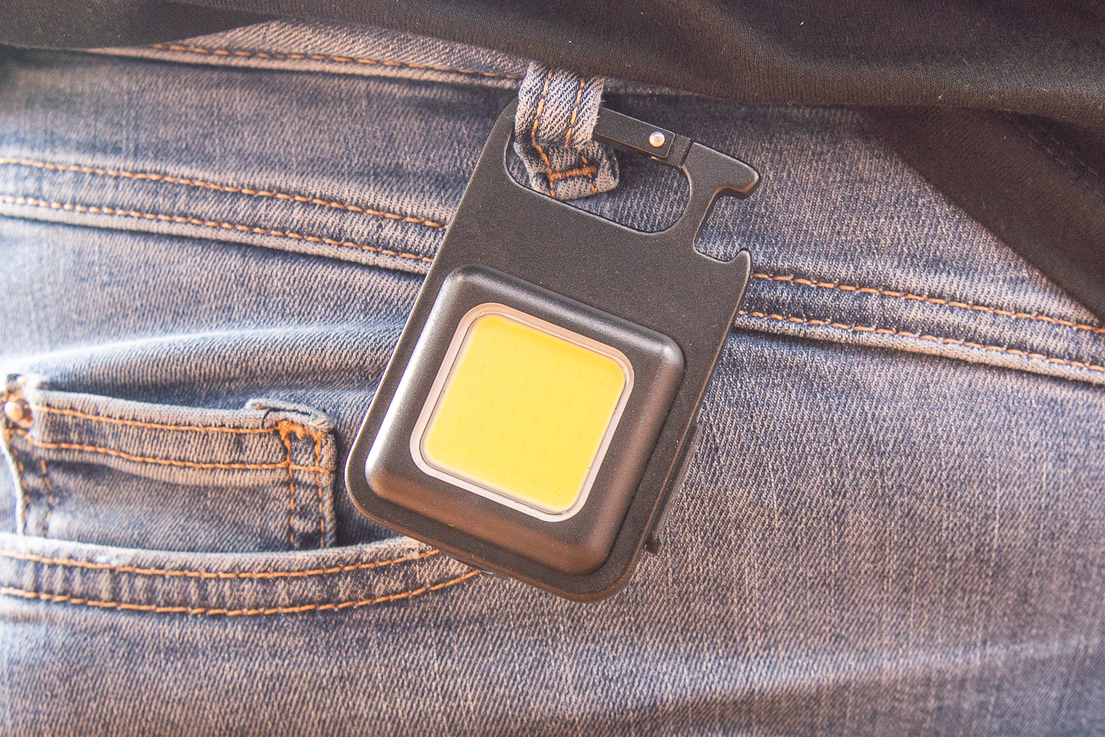 Ein wiederaufladbares Worklight h&auml;ngend an einer Jeanshose.