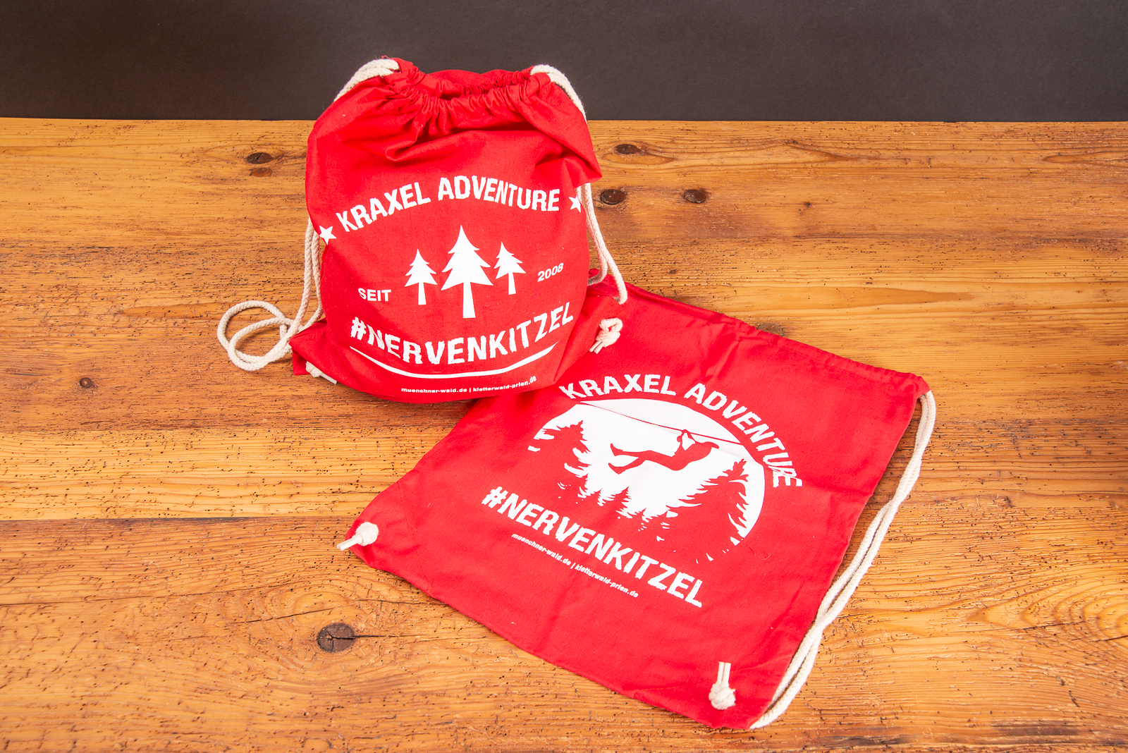 Zwei rote Matchrucks&auml;cke mit wei&szlig;em Werbedruck als Merchandiseartikel.