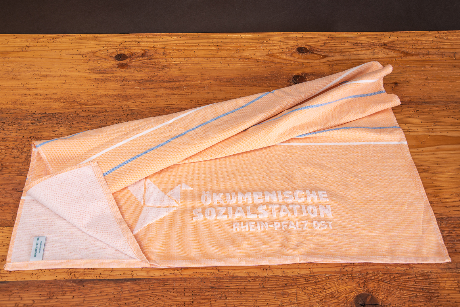 Strandtuch orange mit Einwebung als Werbegeschenk der Sozialstation f&uuml;r Patienten..