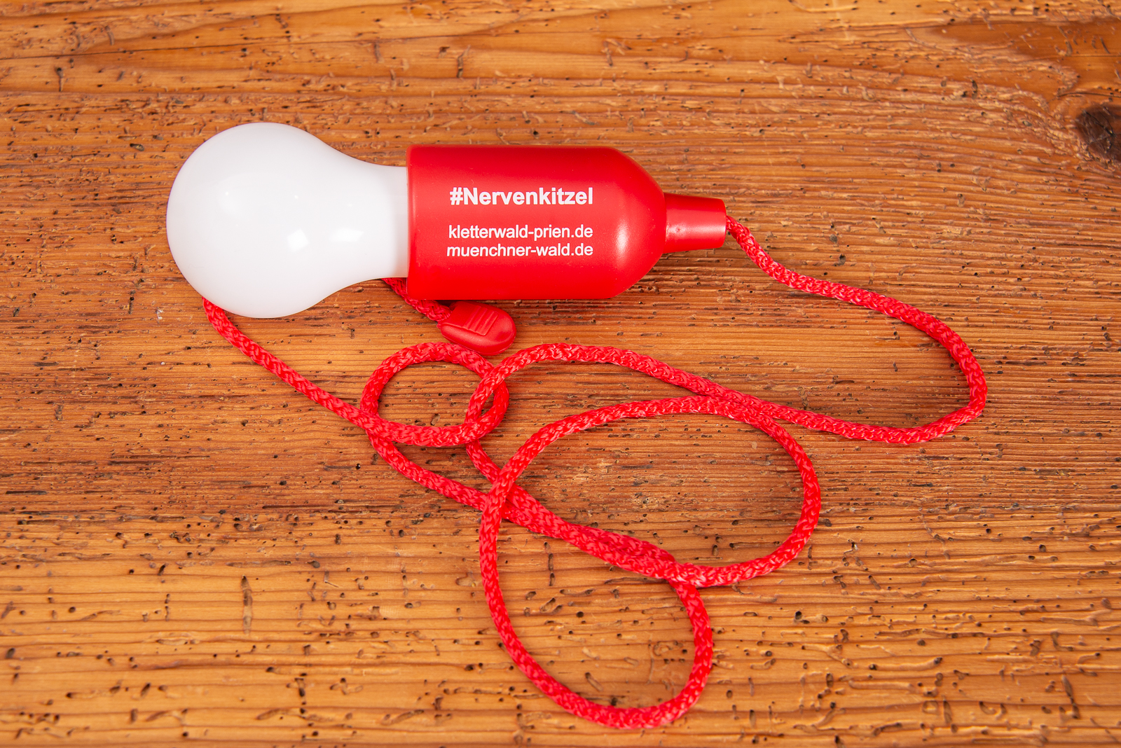 Rote Ziehleuchte mit wei&szlig;em Werbedruck als Merch f&uuml;r Kunden des Kletterwald Prien.