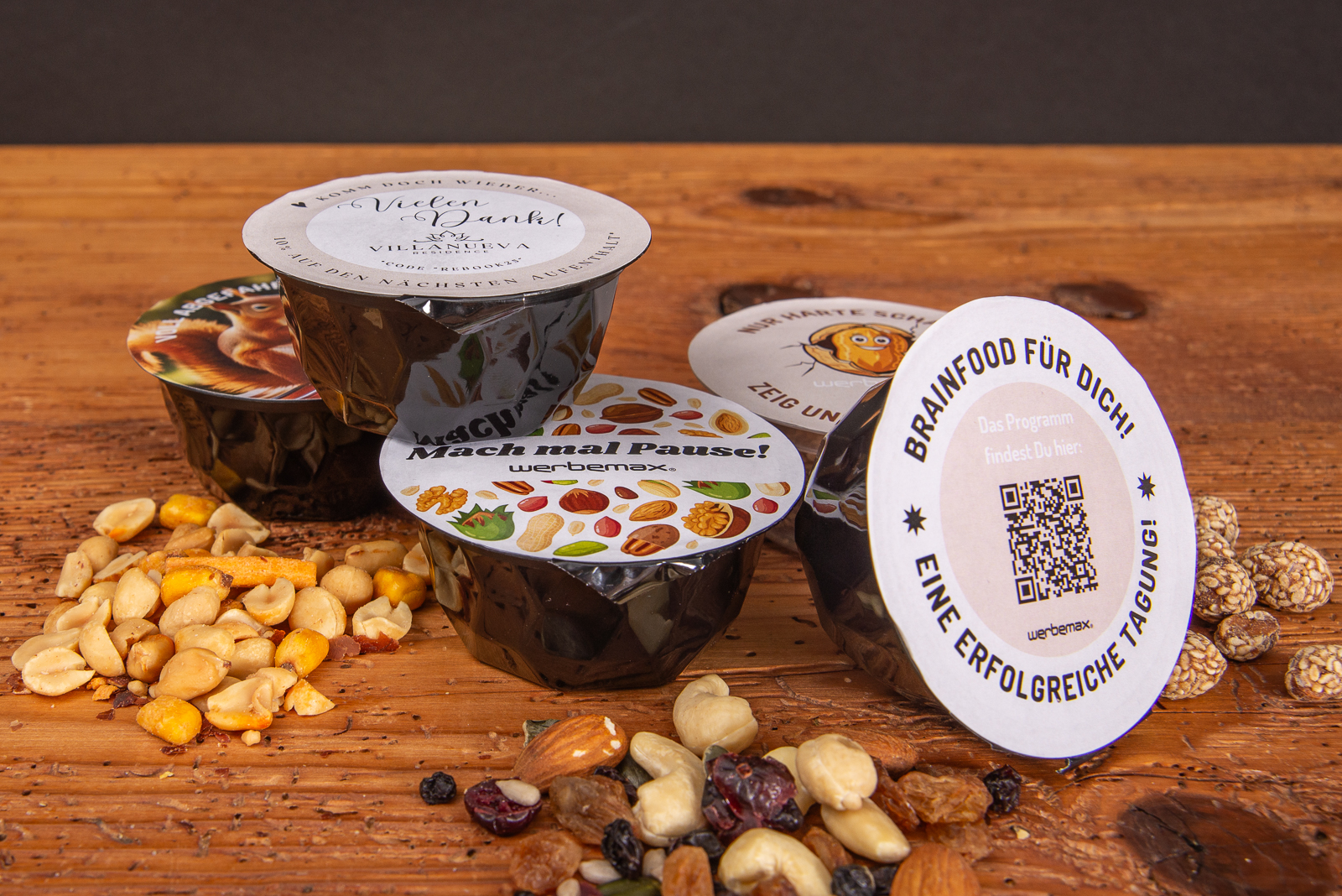 Schwarze nuts-box Nussmischungen mit individuellem Deckel als Giveaway.