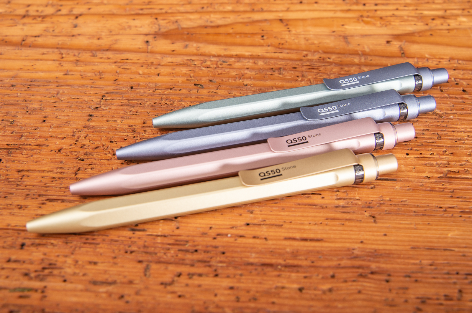 Vier metallicfarbene Prodir QS50 stone Kugelschreiber mit Logo.