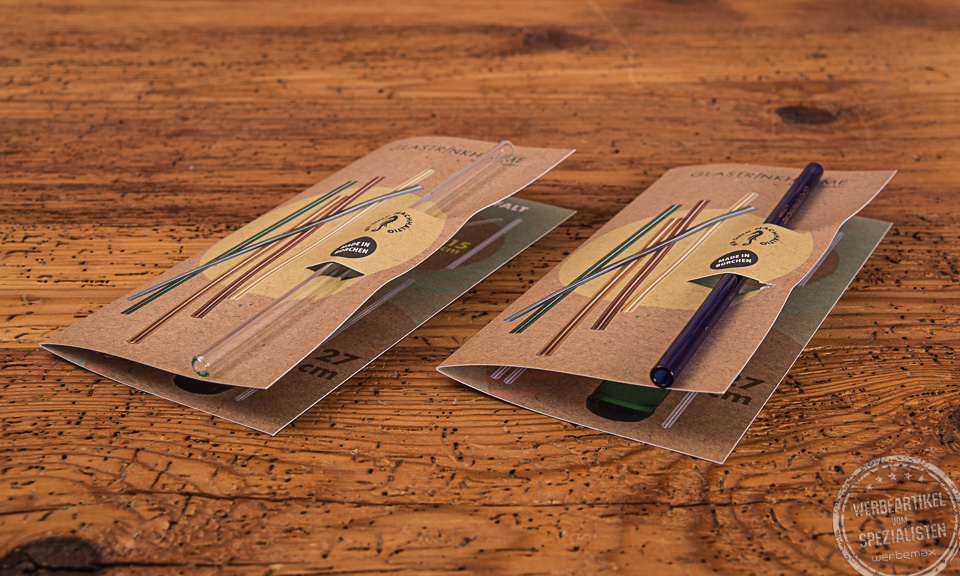 Glasstrohhalme in der Klappkarte als g&uuml;nstiges Merch f&uuml;r Kunden und Mitarbeiter auf Holztisch liegend