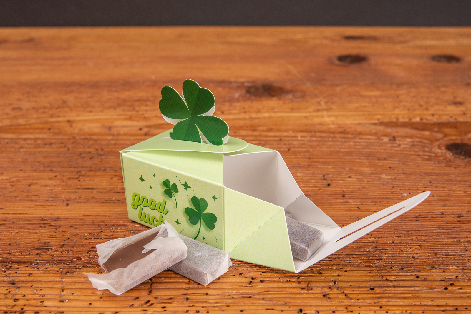 Mini Geschenkbox mit Verschlussform Kleeblatt und Schokolade als Werbeartikel f&uuml;r Kunden.