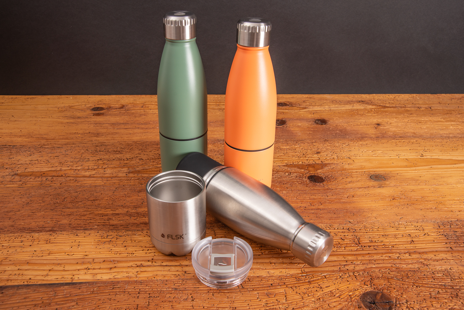 FLSK Thermoflasche mit Becher als nachhaltiger Werbeartikel in 3 Farben auf Holztisch