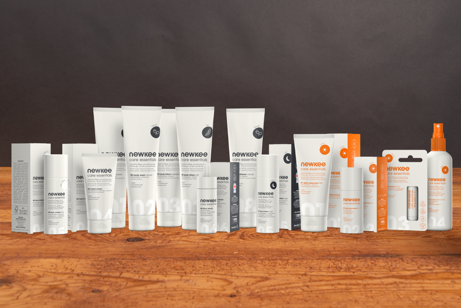 Nachhaltige Newkee Produkt&uuml;bersicht mit Sonnenschutz aufgereiht auf Holztisch