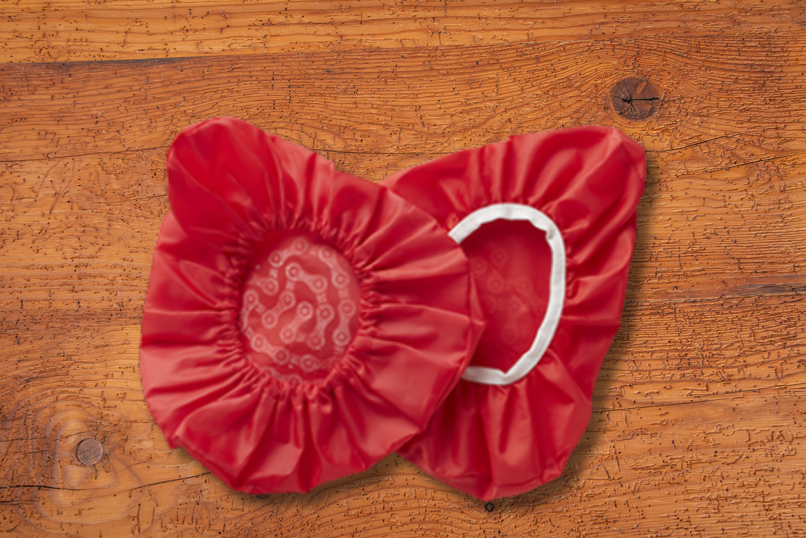 Zwei rote Sattelbez&uuml;ge mit Gummizug und Logodruck als Werbemittel.