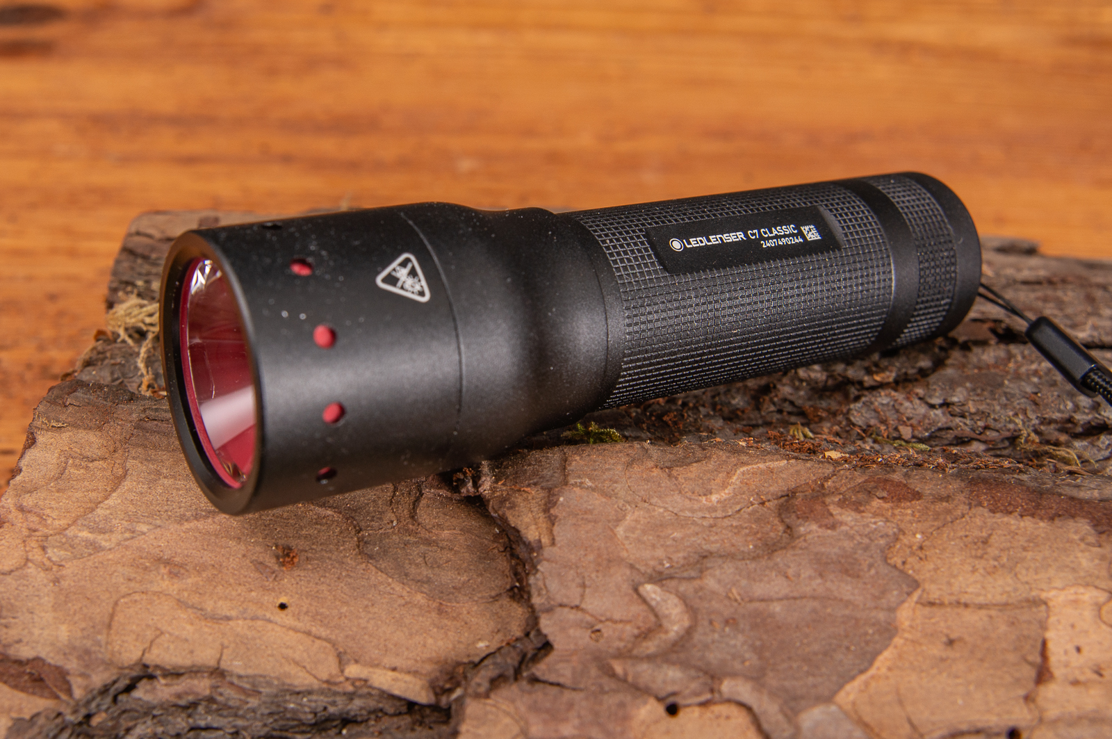 Robuste Taschenlampe C7 Classic von LEDLenser mit einem dezenten Logo das perfekte Mitarbeitergeschenk auf Holz liegend.