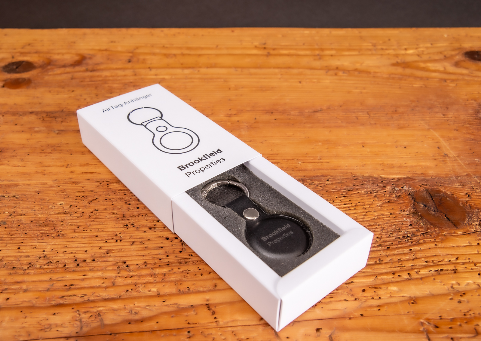 Apple Airtag mit Logogravur auf dem Schl&uuml;sselanh&auml;nger in Geschenkverpackung als Werbegeschenk Referenz Brookfield.
