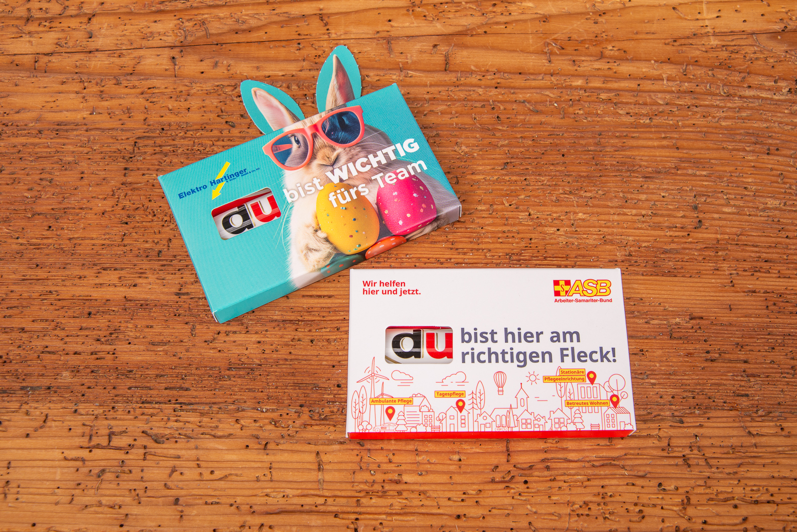 Duplo Schokoriegel im individuell bedruckten Werbeschuber mit Osterdesign, Aufschrift &bdquo;Du bist wichtig f&uuml;rs Team&ldquo;, s&uuml;&szlig;em Hasenmotiv und bunten Ostereiern &ndash; kreativer Werbeartikel zu Ostern f&uuml;r Mitarbeitermotivation und Kundenbindung.
