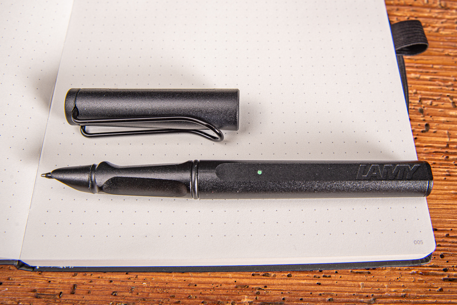 LAMY safari all black Smartpen mit Logo-Gravur als exklusives Werbegeschenk offen auf digital paper Notizbuch liegend.