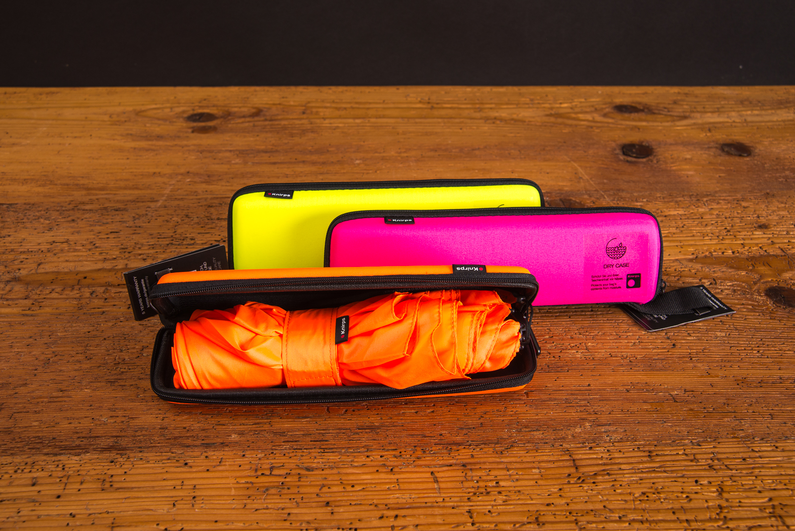 Auff&auml;llig werben, mit der Neon-Reihe der Knirps windproof Taschenschirme X4U auf Holztisch liegend