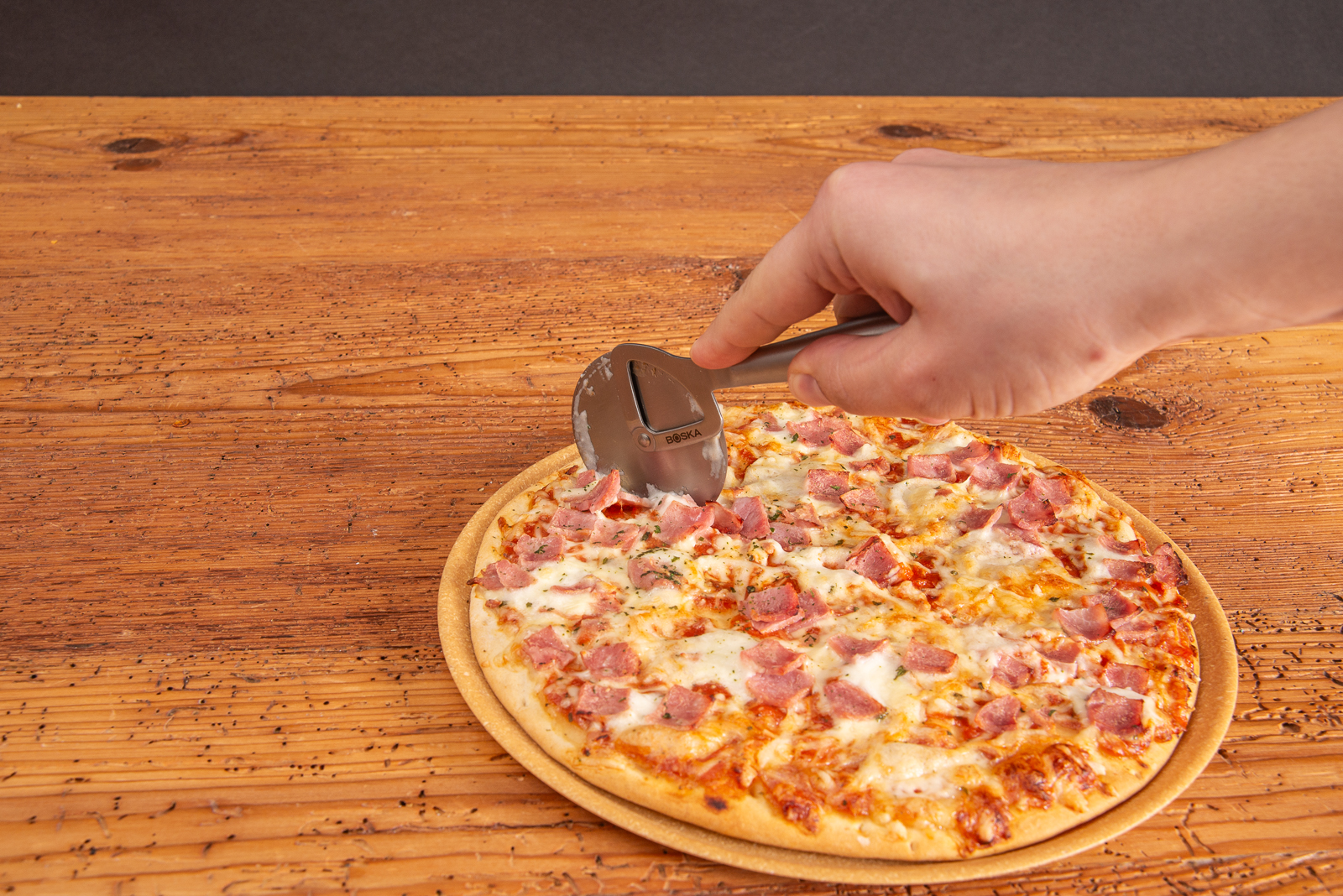 Pizzaschneider aus Edelstahl beim Pizzaschneiden als hochwertiges Werbemittel. Mit Logogravur als Werbegeschenk verschenken.