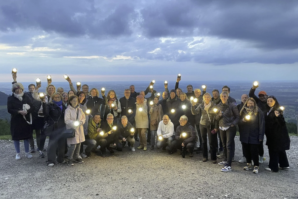 Teilnehmer der AFM Marketingtagung auf dem Berg mit eingeschalteten Troika Laternen in der Hand. 