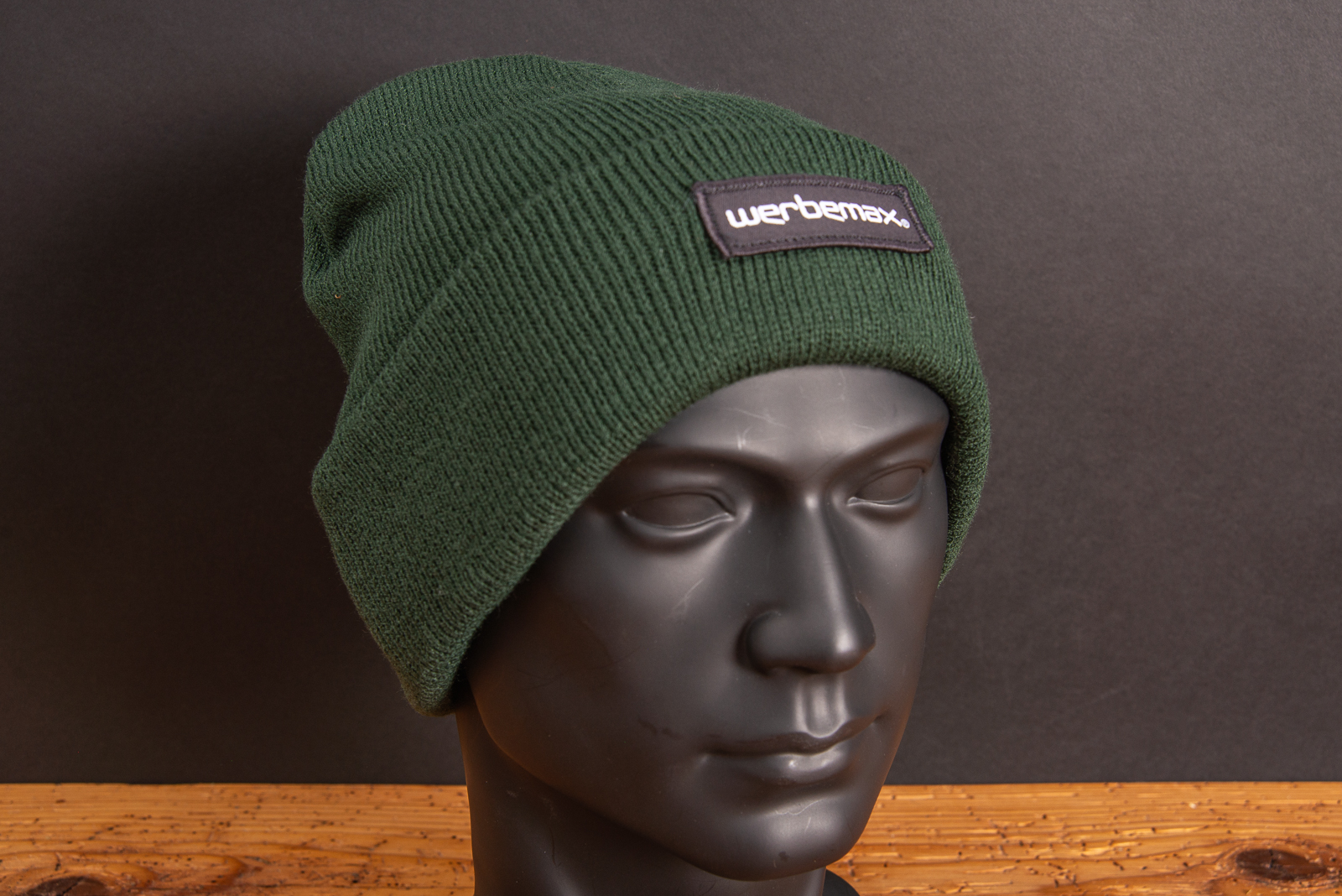 G&uuml;nstige Beanie M&uuml;tze in flaschengr&uuml;n auf Webekopf mit einer coolen Logoanbringung werbemax als Weblabel auf dem Umschlag