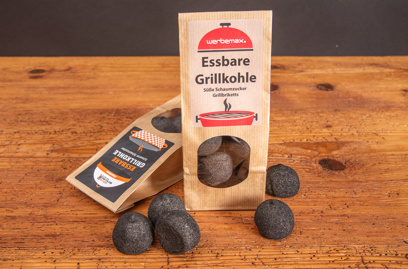 Grillkohle aus Marshmallows im Beutel stehend mit einzelnen auf Holztisch - originelles Giveaway f&uuml;r Sommeraktionen.
