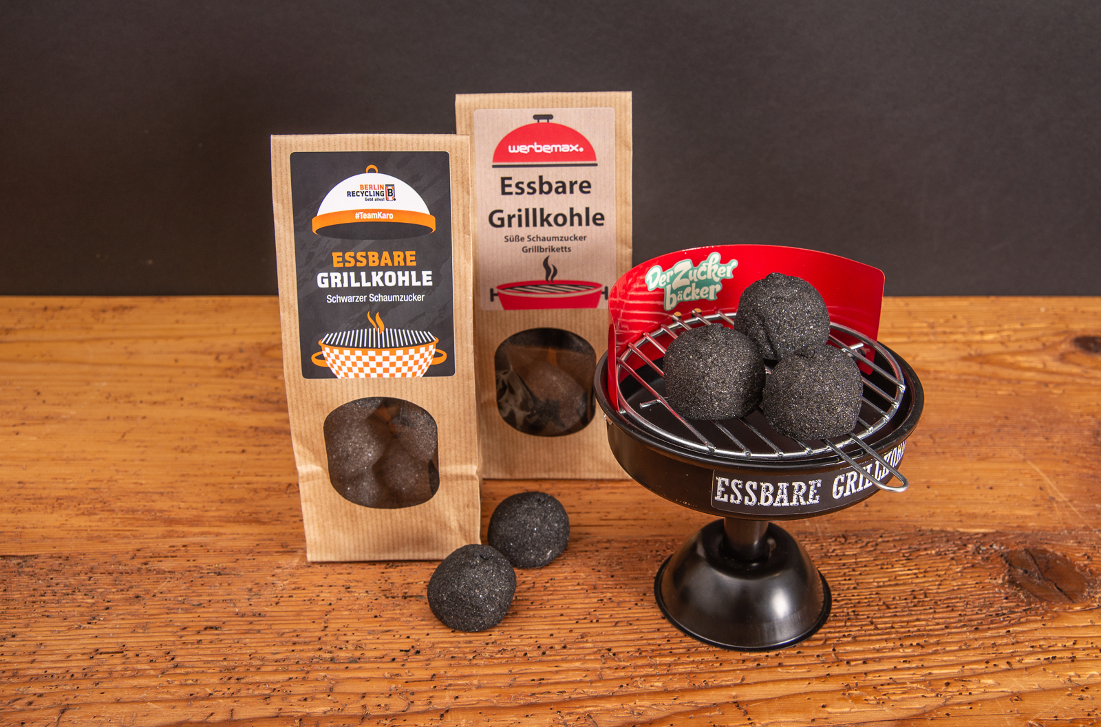 Essbare Grillkohle aus Marshmallow als s&uuml;&szlig;es Merch sch&ouml;n dekoriert auf Grill mit einzelnen marshmallow auf Holztisch