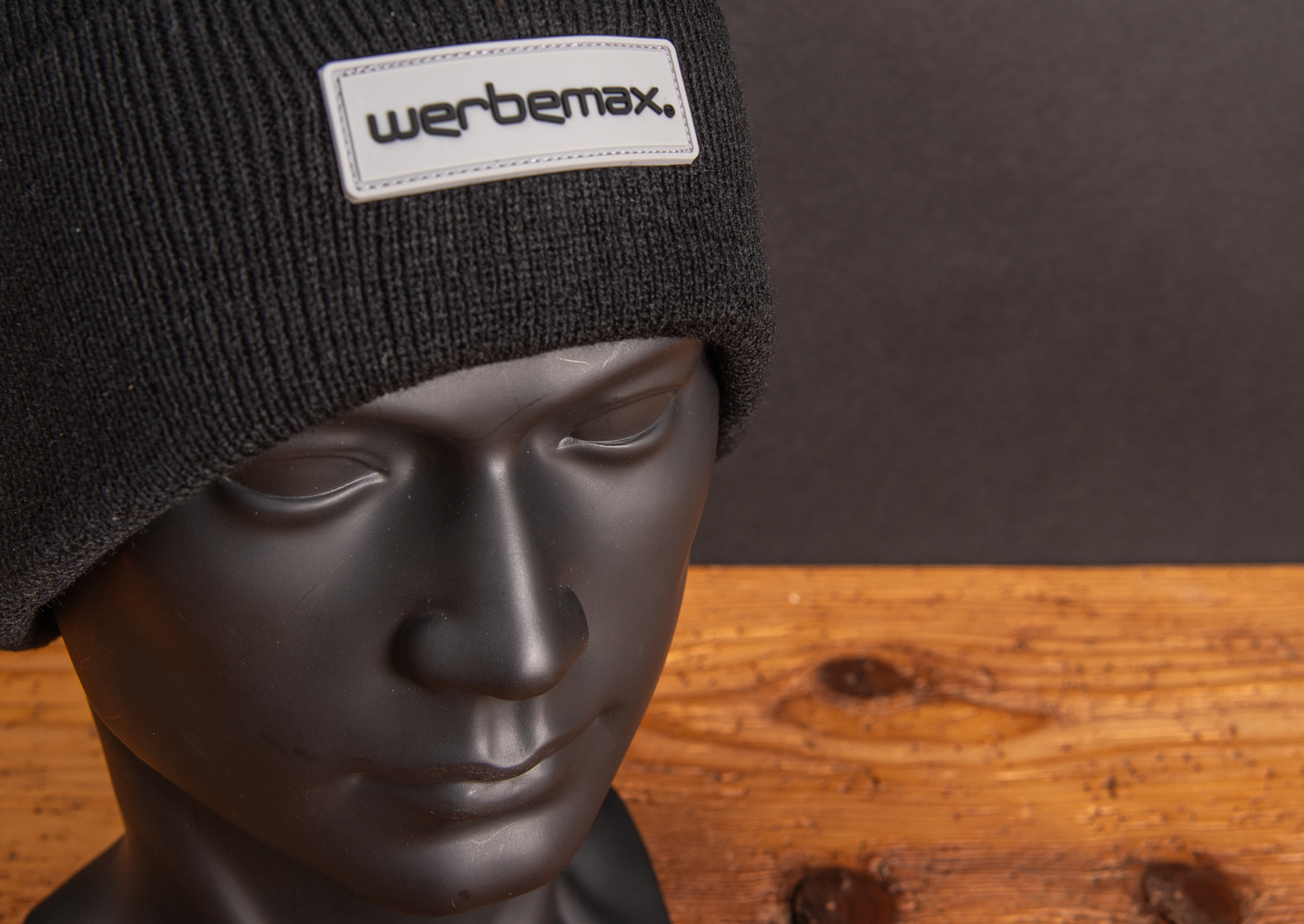 Schlichte Strickm&uuml;tze auf Werbekopf mit Detailfoto vom coolem Logopatch werbemax auf der Stirn.