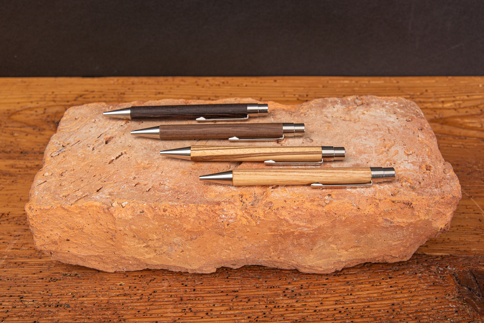 Kugelschreiber VIVO aus FSC-zertifizierten Holz in 5 verschiedenen Ausf&uuml;hrungen mit Logodruck oder Einzelnamengravur auf Backstein liegend