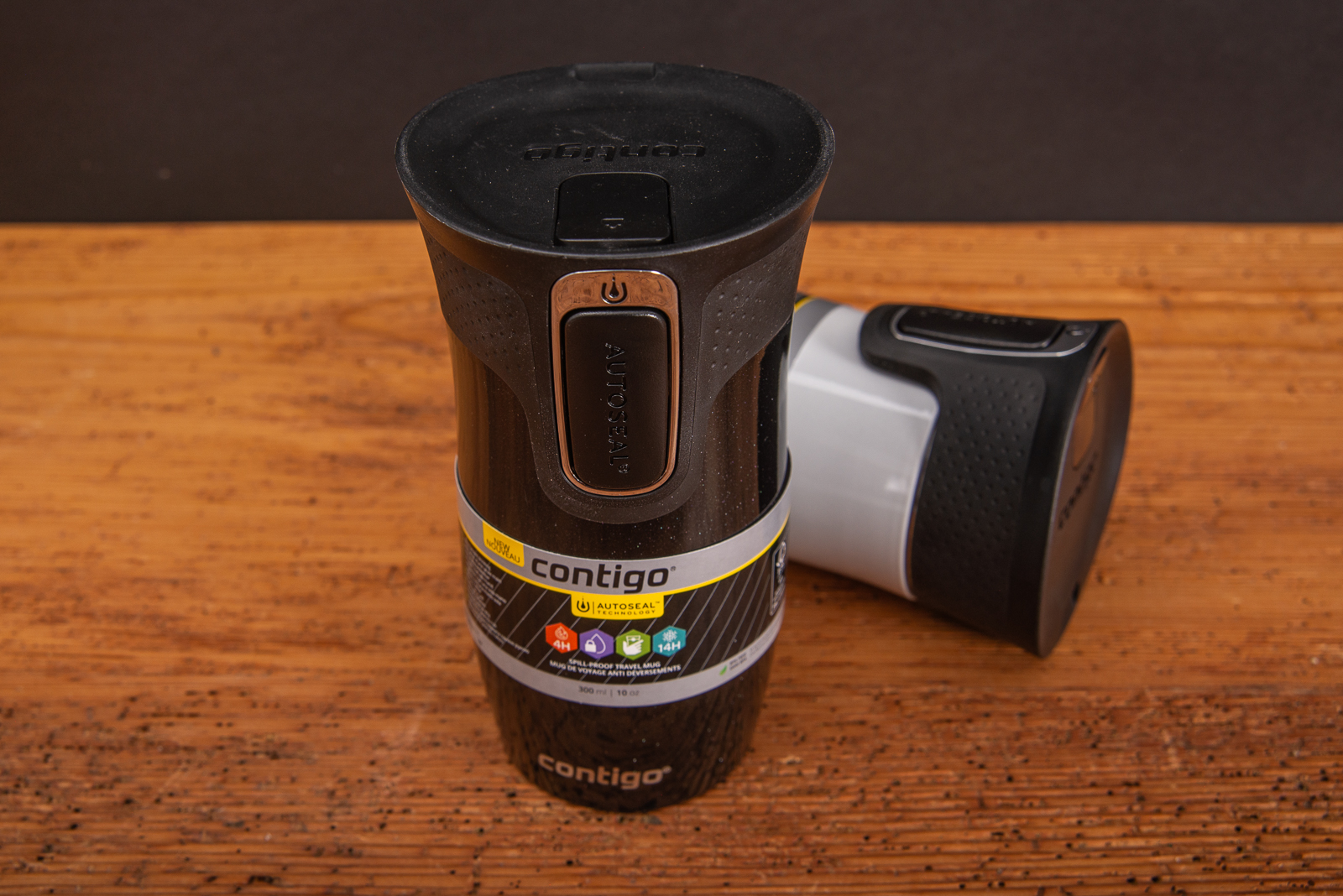 Contigo Thermobecher in schwarz und wei&szlig; mit Einhandverschluss als Werbegeschenk auf Holzplatte.