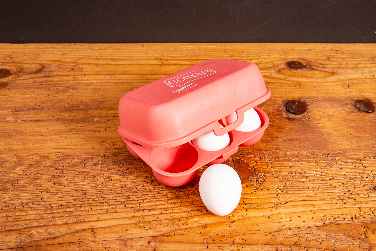 Koziol Eierbox EGGS TO GO mit vier Eiern, halb ge&ouml;ffnet auf Holztisch.