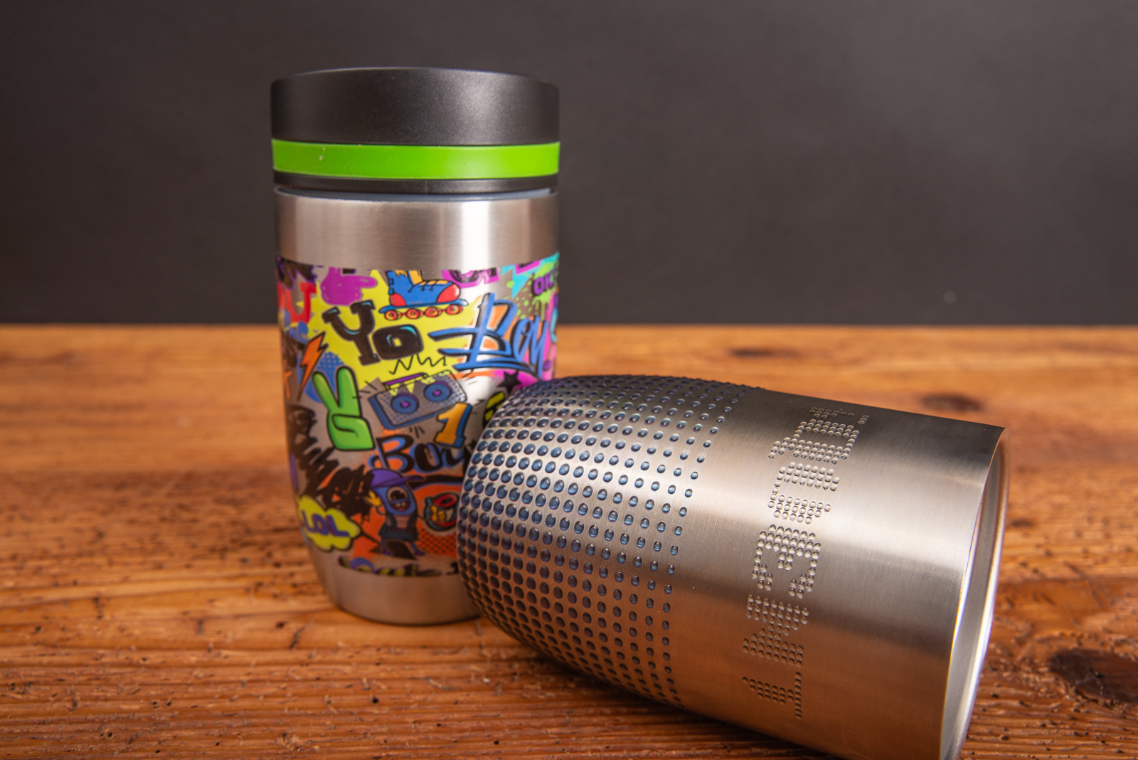 Nahaufnahme des Logos im Reliefdruck &ndash; f&uuml;hlbare Oberfl&auml;che - auf zwei CremaOfficinaBudget Thermobechern.