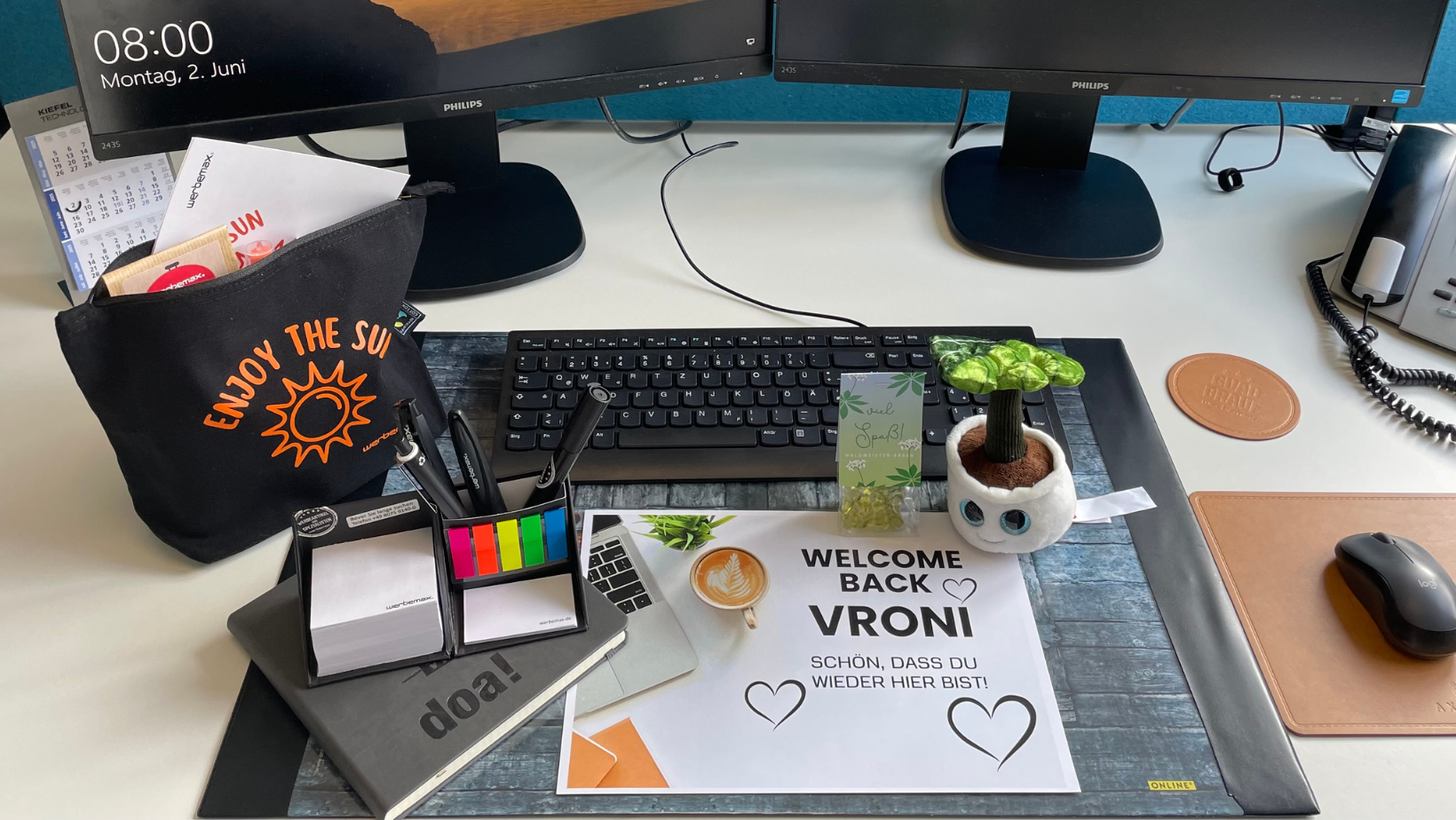 Onboarding mit Herz: Begr&uuml;&szlig;ungs-Set f&uuml;r neue Mitarbeiter mit personalisierter Willkommenskarte, praktischen Werbegeschenken wie Notizbuch, Post-Its, Kugelschreibern, einer Kosmetiktasche mit &bdquo;Enjoy the Sun&ldquo;-Aufdruck und einem s&uuml;&szlig;en Schmoozies Displayreiniger in Pflanzenform &ndash; ideal f&uuml;r einen gelungenen Start und starke Mitarbeiterbindung.