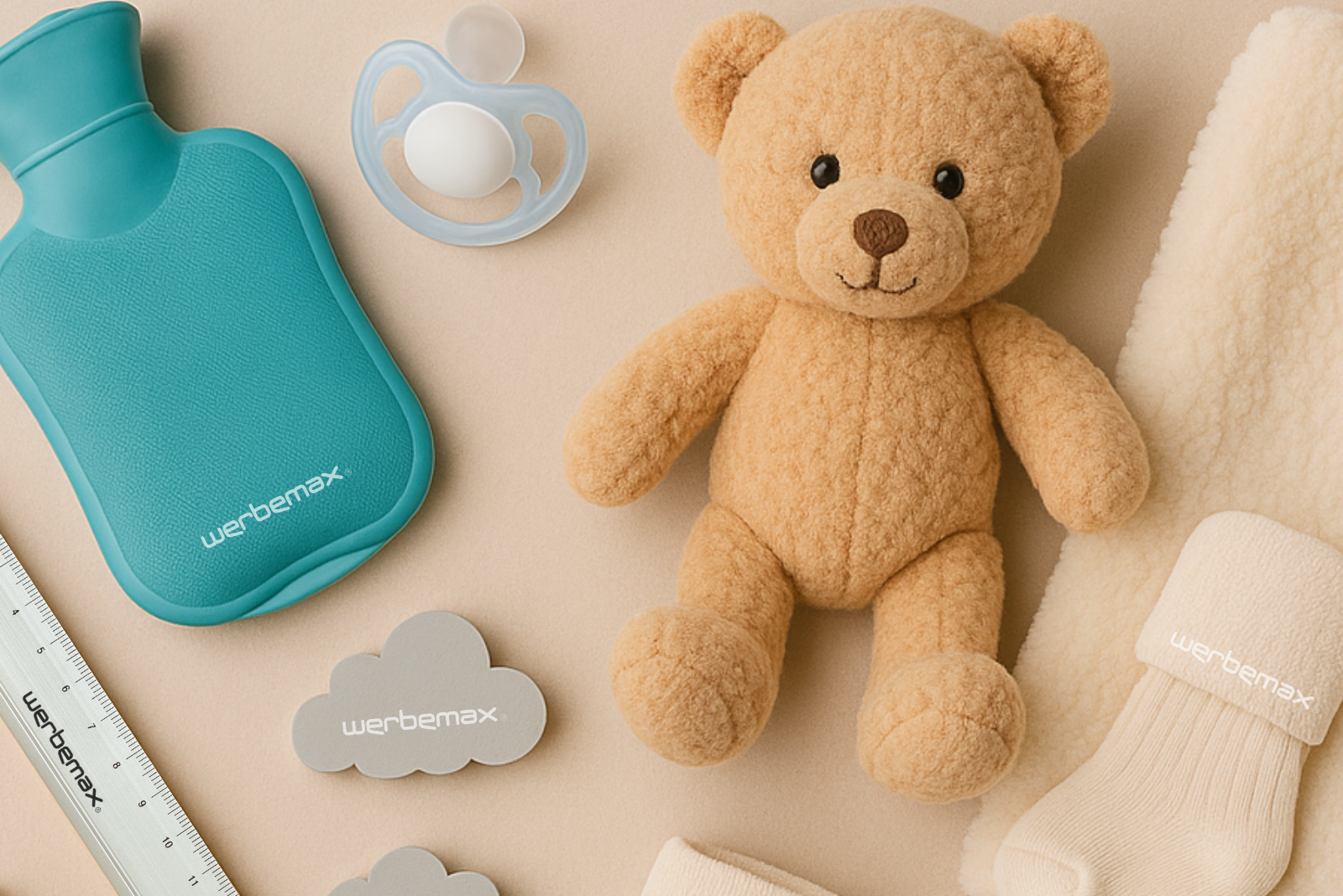 Teddyb&auml;r, W&auml;rmflasche, Socken und Schnuller als Werbegeschenk-Ideen zur Geburt.