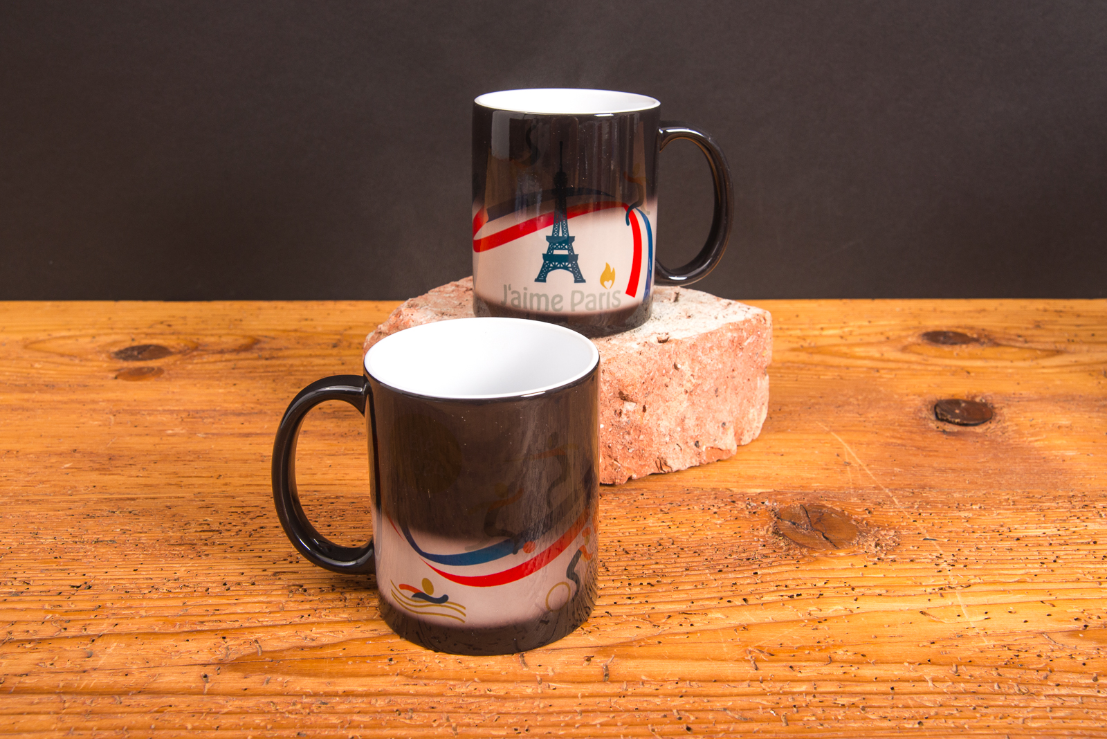 Zwei Kaffeetassen mit Magic-Farbwechseldruck und Paris-Motiv im &Uuml;bergang &ndash; individuelle Werbeartikel Tassen mit Thermoeffekt von werbemax.