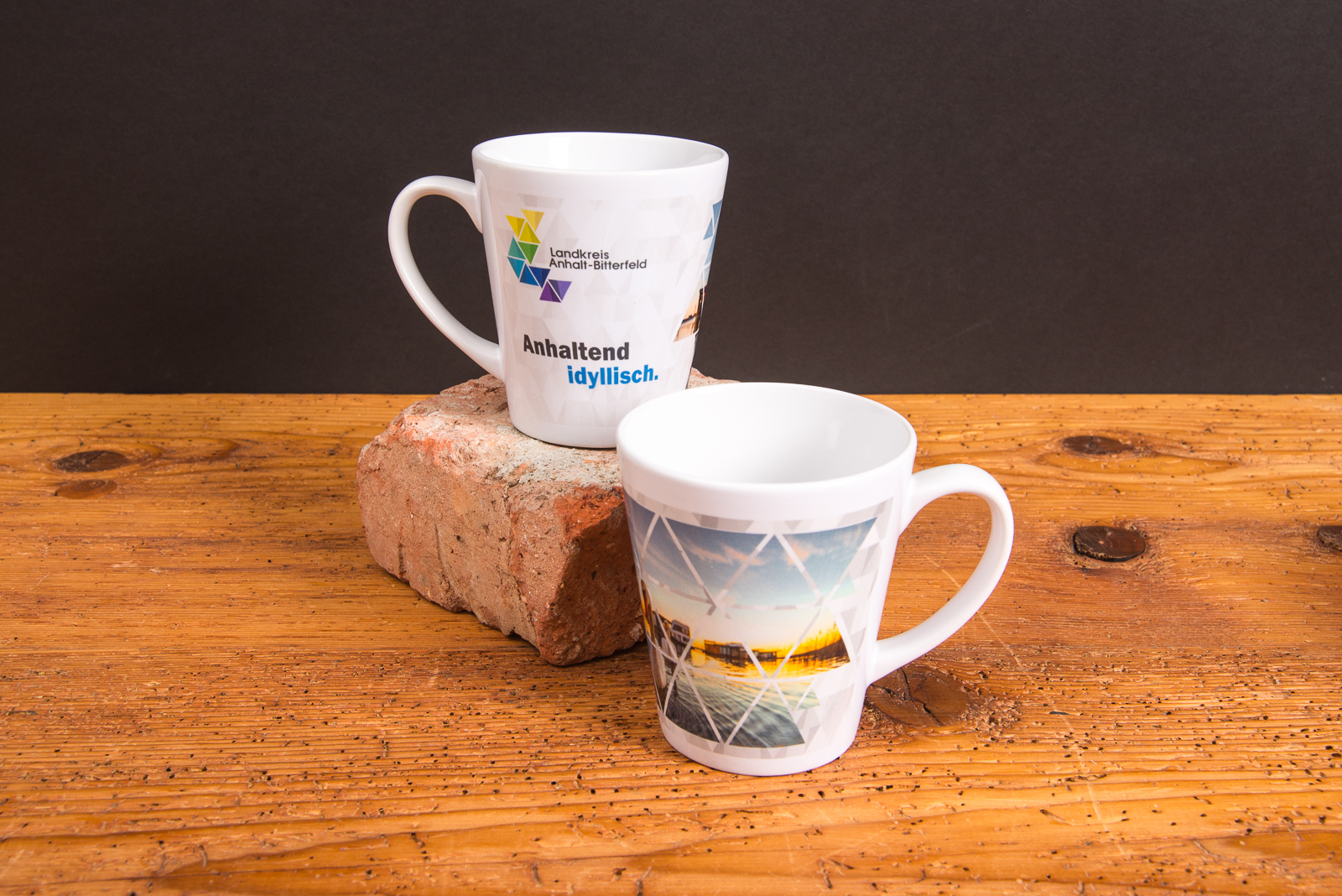 Zwei bedruckte Fototassen mit Logo und Landschaftsmotiv f&uuml;r den Landkreis Anhalt-Bitterfeld &ndash; Werbeartikel Tassen als regionale Markenbotschafter.