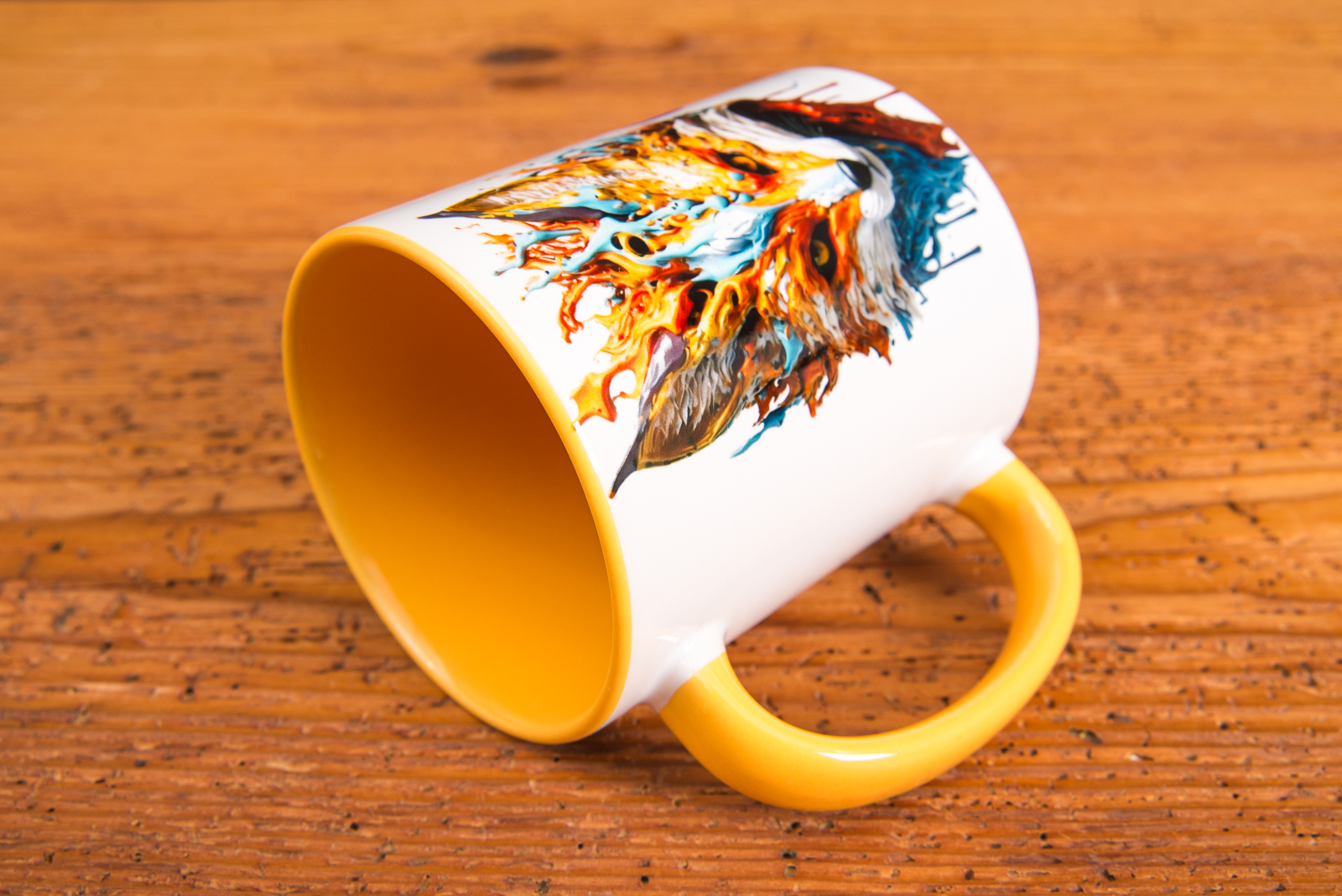 Keramiktasse mit gelber Innenglasur und farbstarkem Fuchs-Motiv &ndash; kreativ bedruckte Werbeartikel Tasse auf rustikalem Hintergrund.