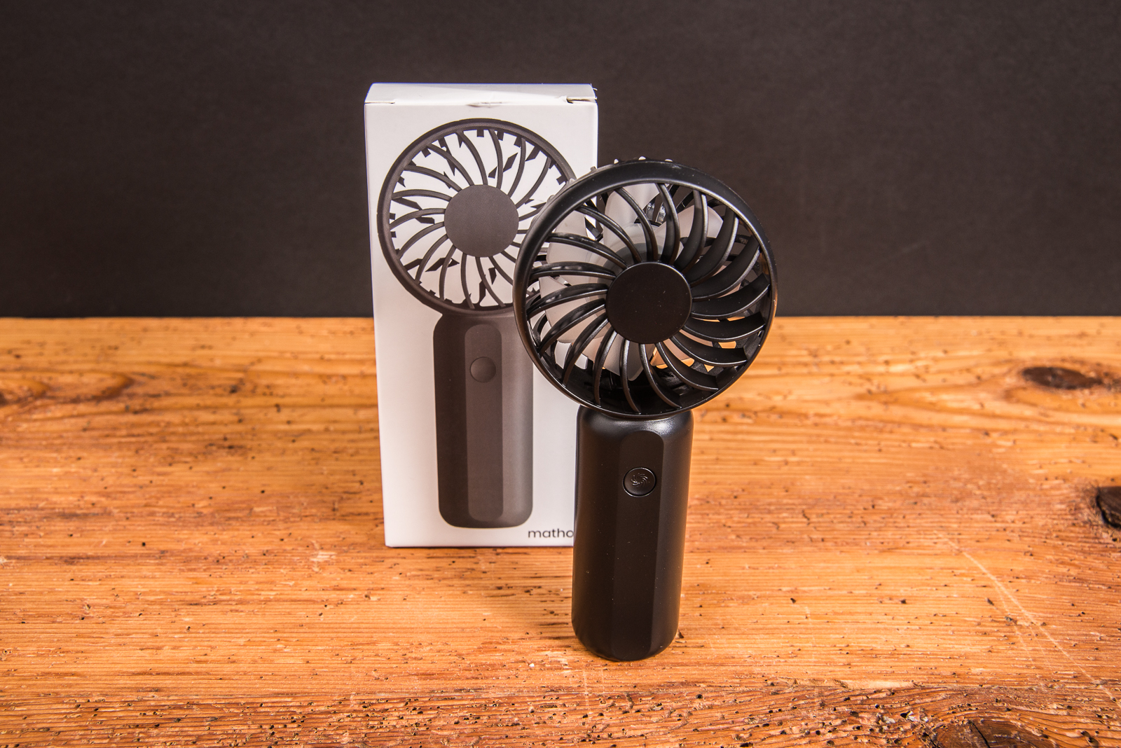 Schwarzer Handventilator Breezy als Werbeartikel mit Logo, vor der passenden Einzelverpackung pr&auml;sentiert &ndash; modernes Sommer-Werbegeschenk.