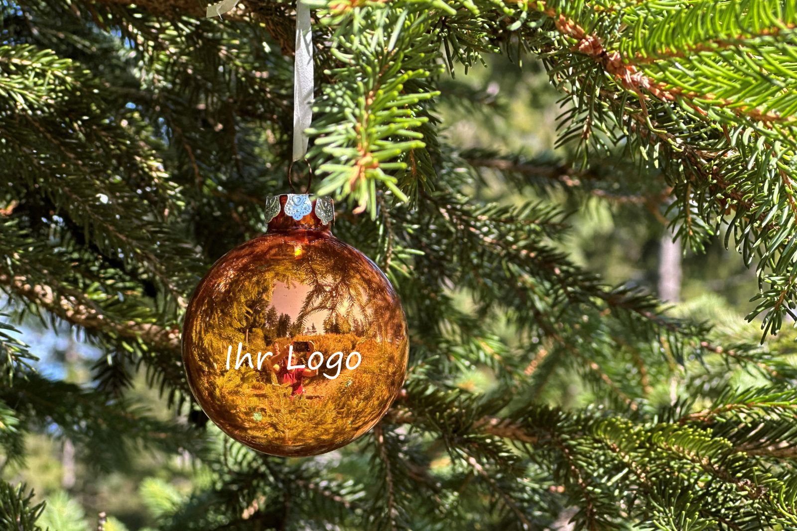 Goldene personalisierte Weihnachtskugel mit Logo am Tannenbaum als Werbegeschenk f&uuml;r Kunden und Mitarbeiter.
