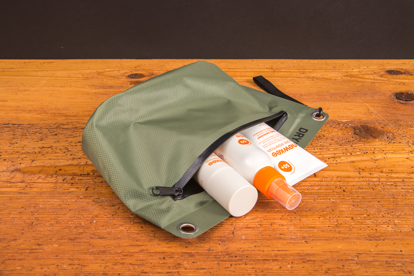 Gr&uuml;ne Halfar Drybag 3L Tasche als Werbeartikel, ge&ouml;ffnet mit Sonnencreme und Pflegeprodukten &ndash; wasserdichter Begleiter f&uuml;r Strand, Outdoor und Reisen.