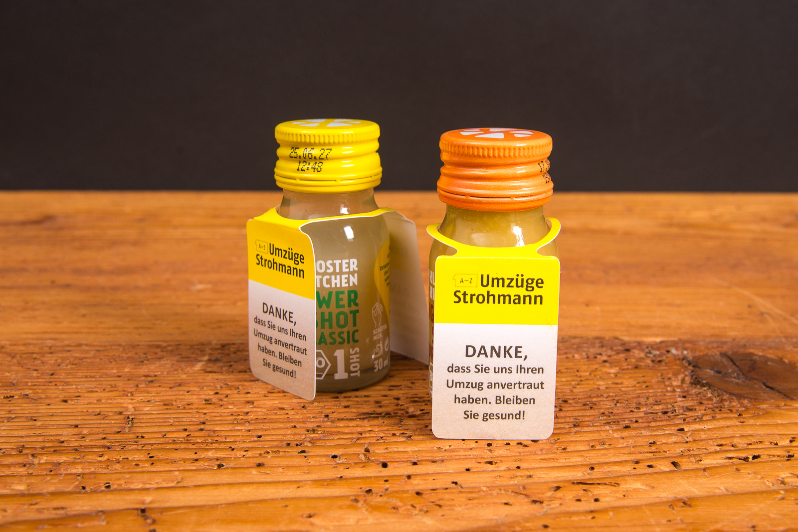 Zwei Kloster Kitchen Ingwer Shots mit individuell bedrucktem Logo-Cape als personalisiertes Werbegeschenk.