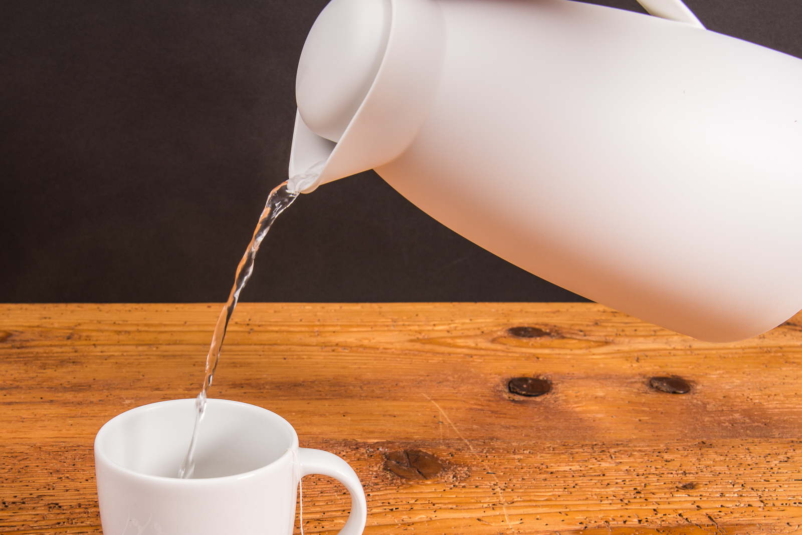 Wei&szlig;er. g&uuml;nstiger und einfacher Becher aus Porzellan von SND, bef&uuml;llt mit hei&szlig;em Wasser aus Thermoskanne.