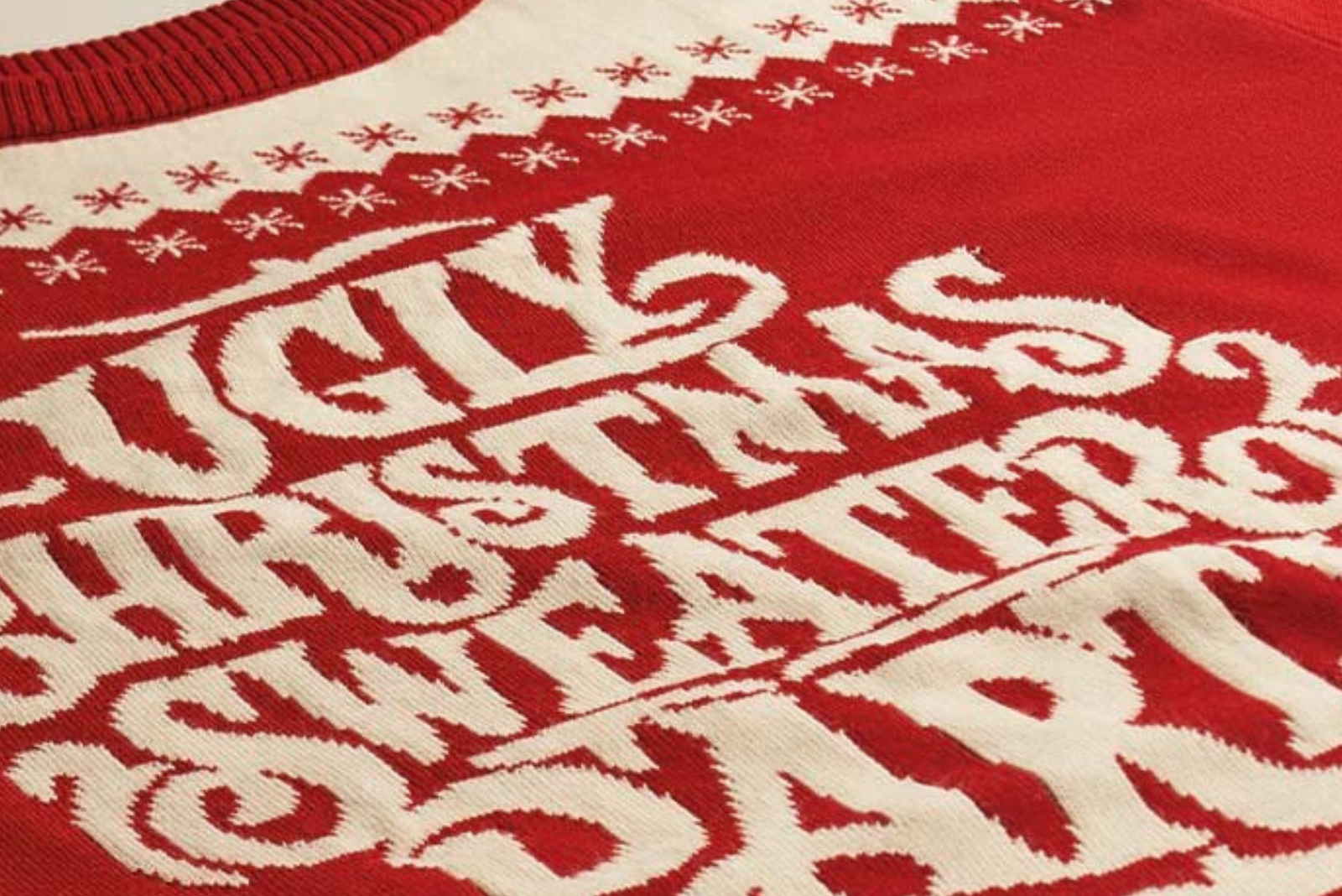 Nahaufnahme: roter Ugly Christmas Sweater mit cremefarbenem Strickmuster als Werbegeschenk.