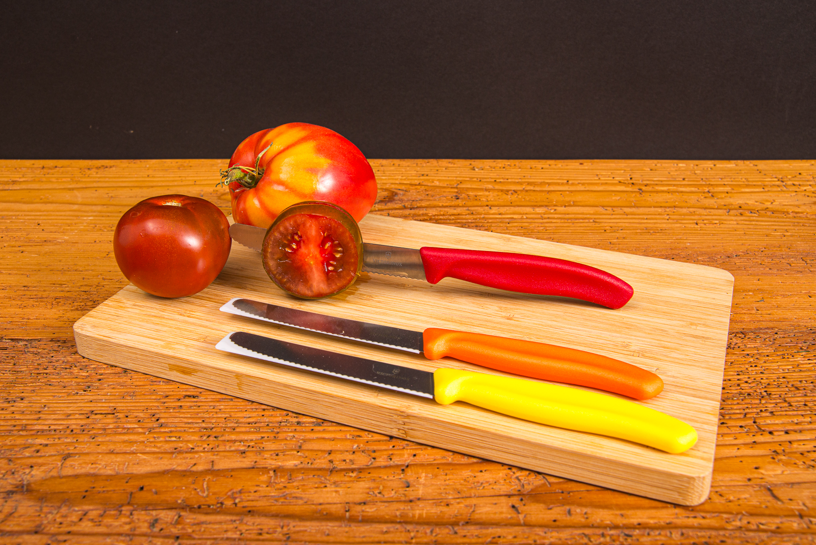 Victorinox Tomatenmesser mit Gravur auf Holzbrett neben Tomaten &ndash; perfektes Werbemittel f&uuml;r K&uuml;che und Genuss.