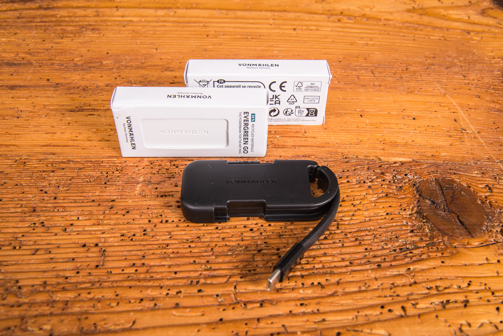 Vonm&auml;hlen Evergreen Go Powerbank in Schwarz vor zwei wei&szlig;en Verpackungen mit Logo.