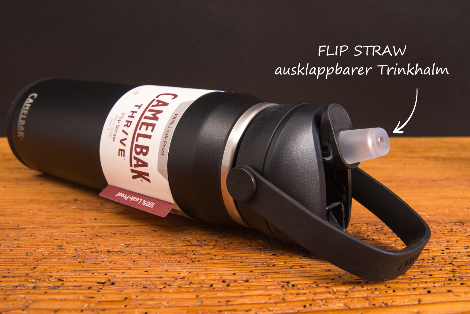 CamelBak Thrive Trinkflasche Flip Straw mit ausklappbarem Trinkhalm &ndash; Premium Incentiv f&uuml;r aktive Marken liegend auf Holztisch.