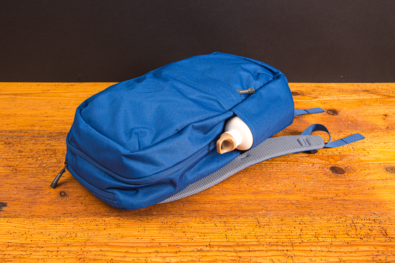 Deuter Rucksack DI Pack 23 mit SIGG Flasche in der praktischen Seitentasche. Liegen auf einem Holztisch fotografiert. Modernes Design, dass unisex gerne getragen und kombiniert wird.  Mit individuellem Logostick ein sch&ouml;nes Mitarbeitergeschenk.