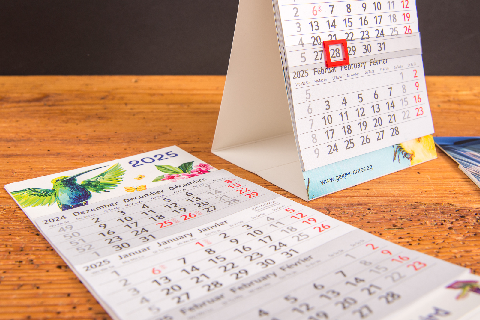 Nachhaltiger Tischaufstellkalender mit Logo &ndash; 3-Monatskalender aus Recyclingpapier mit Blauem Engel, mit rotem Datumsschieber und gro&szlig;er Werbefl&auml;che, als g&uuml;nstiges Werbegeschenk f&uuml;rs B&uuml;ro und Jahresendmailing.