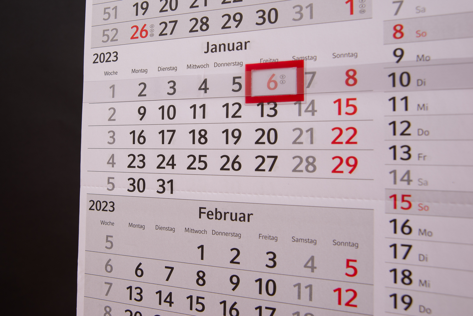 Roter Datumsschieber in der Nahaufnahme. Das Kalendarium ist hellgrau die Sonn- und Feiertage in rot aufgedruckt. Ein &uuml;bersichtliches Werbegeschenk f&uuml;r wenig Geld.