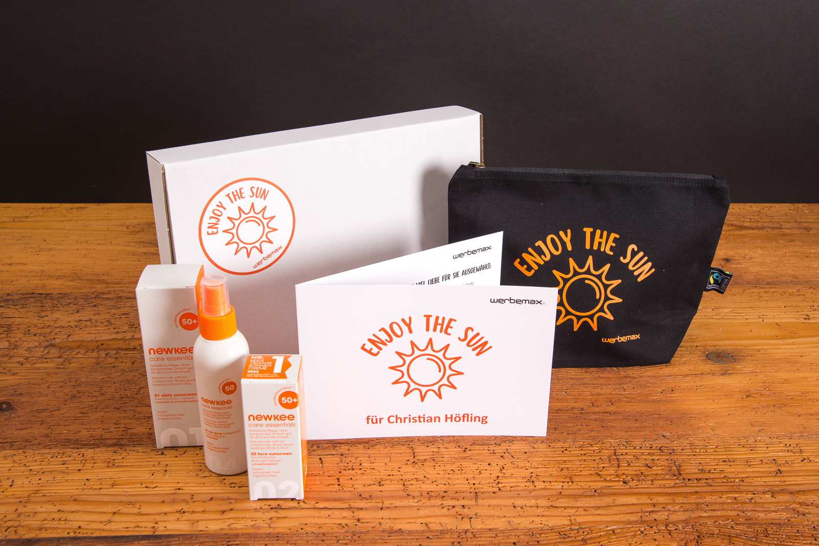 newkee Pflegeprodukte im &bdquo;Enjoy the Sun&ldquo;-Set mit personalisierter Karte, Mister Bags Toiletbag und individueller Verpackung von werbemax.
